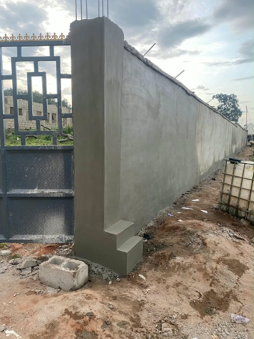 Company site photograph showing a plastered perimeter wall and gate after completion of the works