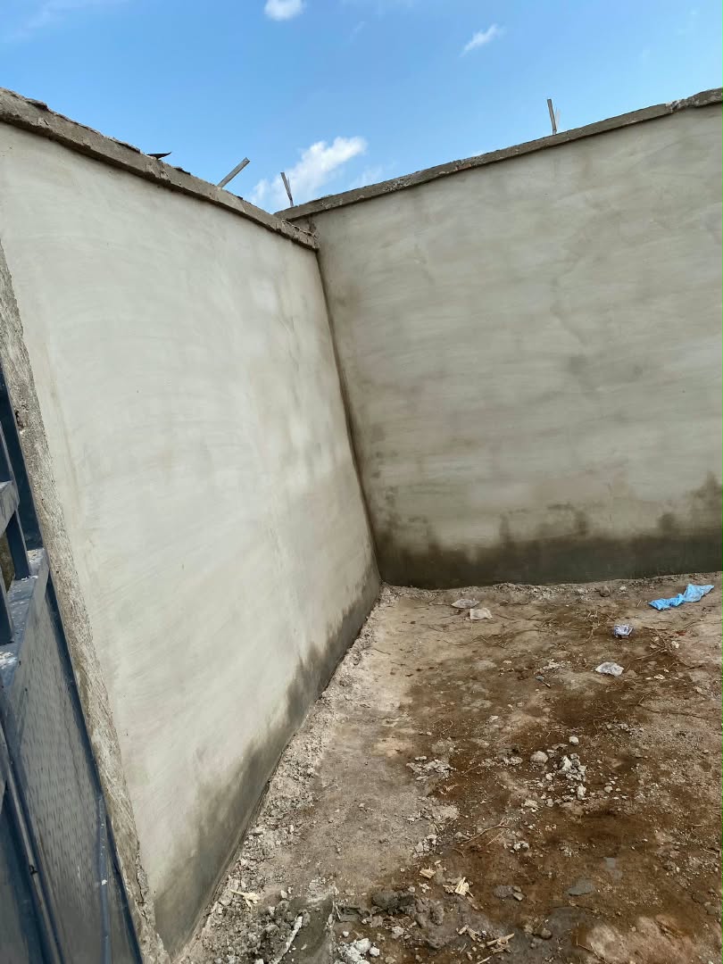 Company site photograph showing an unplastered perimeter block wall corner before plastering